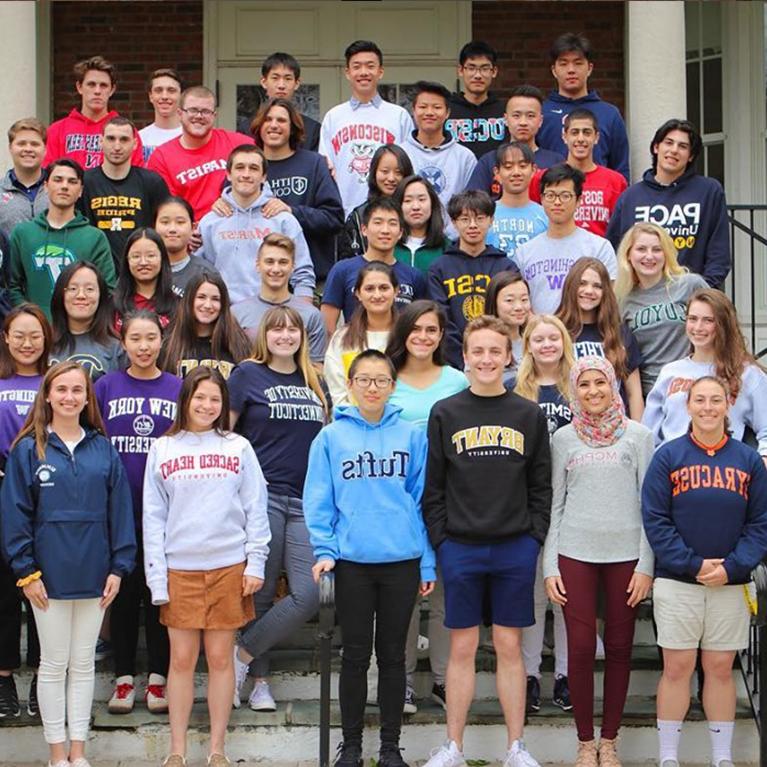 Chase Collegiate seniors pose outside in the shirts of the colleges they are going to in the Fall.